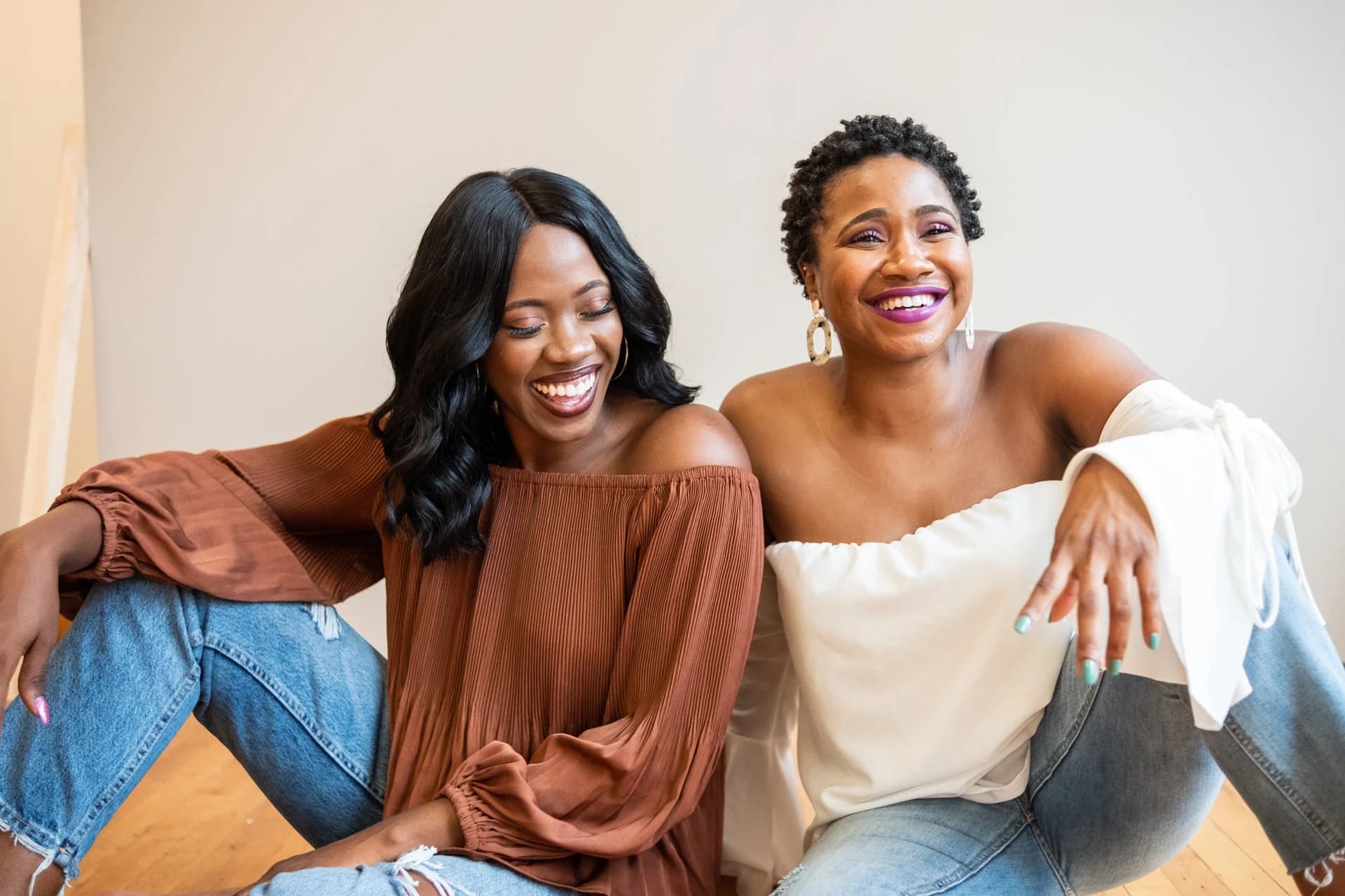 Two people sitting together, one laughing mid-sentence